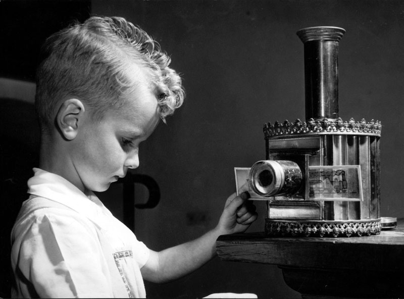 Little boy with an early magic lantern at the exhibition Play and the Child, Delft, Netherlands. Date: 1953