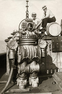 Diver in metal diving suit attached to cable