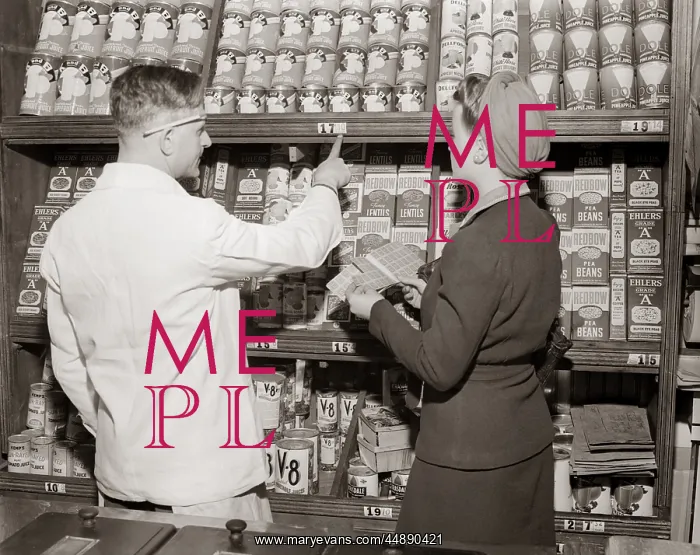  : 1940s Back View Of Grocer Pointing
