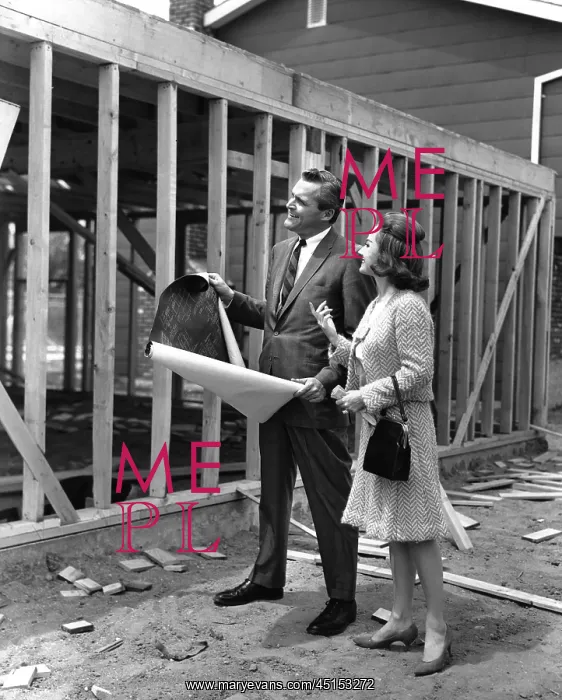: 1950's couple standing in front of their new extension : 1950's couple standing in front of their new extension
