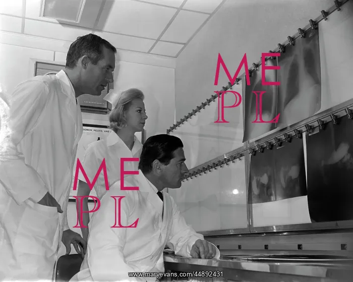 : 1950s TWO DOCTORS AND NURSE EXAMINING X-RAYS : 1950s TWO DOCTORS AND NURSE EXAMINING X-RAYS