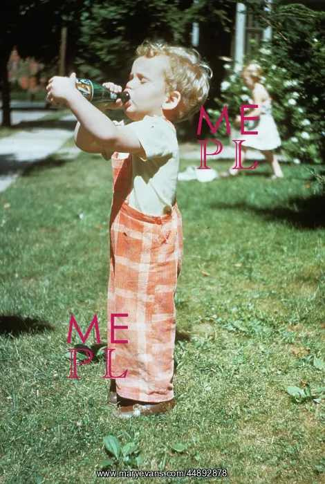 : 1950s LITTLE BOY OUTSIDE DRINKING SODA FROM A : 1950s LITTLE BOY OUTSIDE DRINKING SODA FROM A