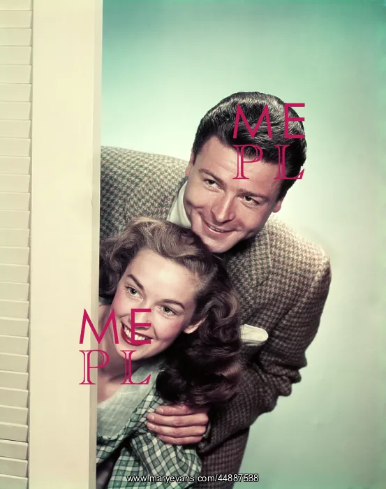  : 1950s SMILING COUPLE PEEKING AROUND CORNER OF