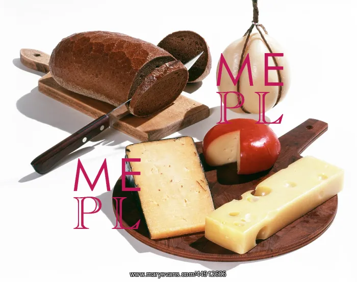 : 1960s brown bread and cheeses on cutting board : 1960s brown bread and cheeses on cutting board