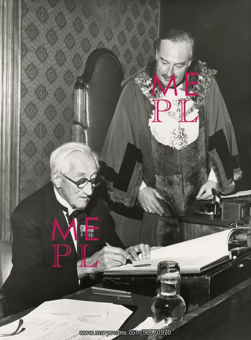 : A. P. Herbert signing an official document : A. P. Herbert signing an official document