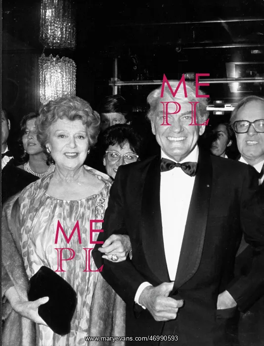 : Actor Jean Marais escorting a woman to an event : Actor Jean Marais escorting a woman to an event