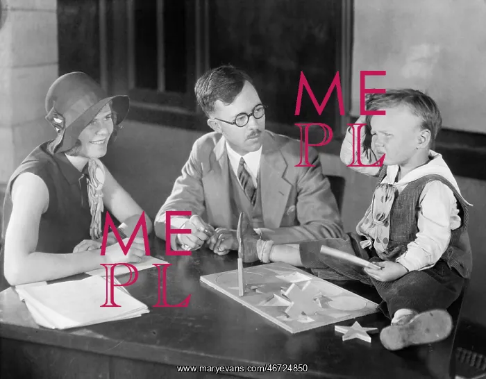 : Adults testing little boy doing puzzle : Adults testing little boy doing puzzle