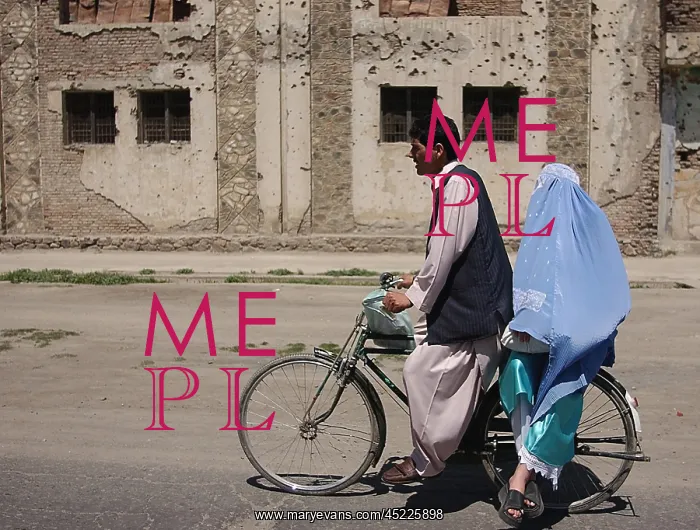 : An Afghani couple rides a bicycle through ? : An Afghani couple rides a bicycle through ?