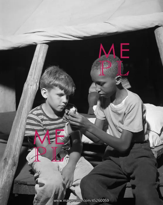 : African American camper helps a White bubby with : African American camper helps a White bubby with