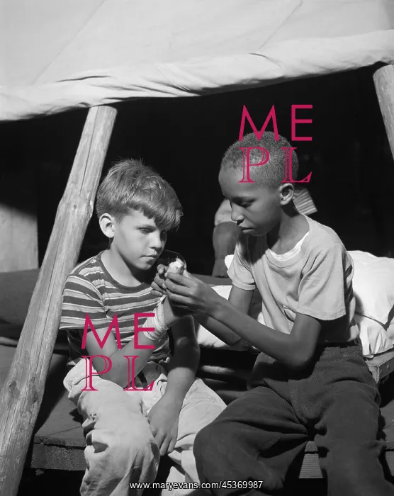: African American camper helps a White bubby with : African American camper helps a White bubby with