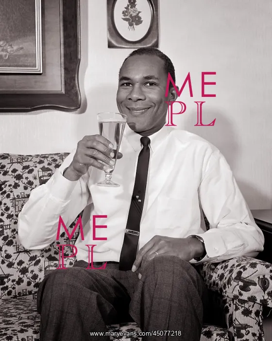 : African-American Man Smiling Sitting on Couch Drinking : African-American Man Smiling Sitting on Couch Drinking