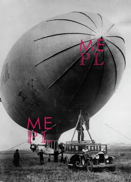: Airship. A small blimp is attached by a mast on the roof of a bus : Airship. A small blimp is attached by a mast on the roof of a bus