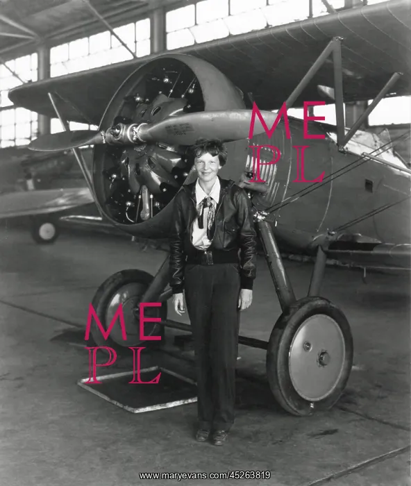  : Amelia Earhart standing next to an airplane, July