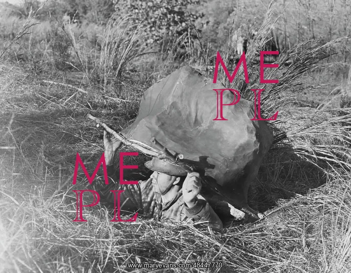 : American soldier emerging from a foxhole concealed : American soldier emerging from a foxhole concealed