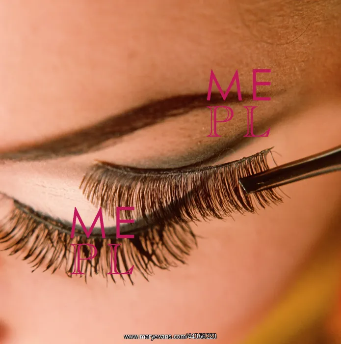  : Applying false eyelashes to female model