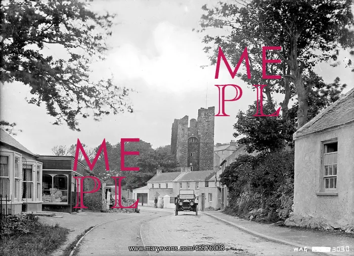 : Ardglass - a view of the town looking up to the Castle with a motor car on the road : Ardglass - a view of the town looking up to the Castle with a motor car on the road