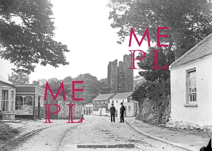 : Ardglass - a view of the town looking up to the Castle with two men on the road : Ardglass - a view of the town looking up to the Castle with two men on the road