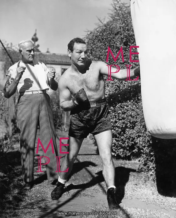 : Athlete with his trainer working on a punching bag : Athlete with his trainer working on a punching bag