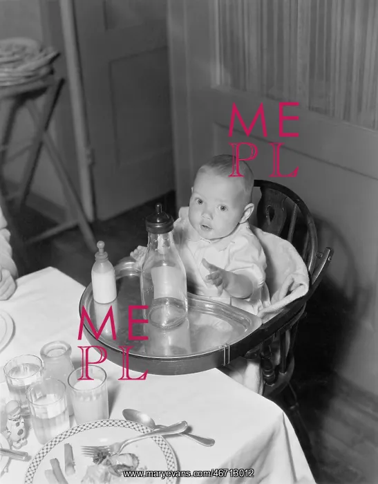 : Baby in highchair with large and small bottles : Baby in highchair with large and small bottles