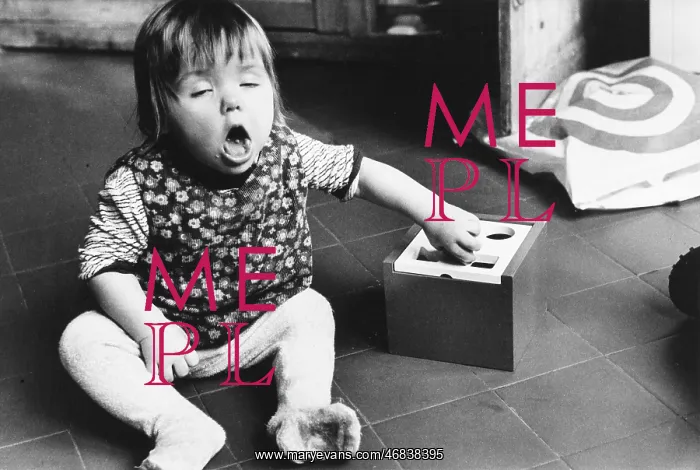 : A baby sits on the floor with a toy : A baby sits on the floor with a toy