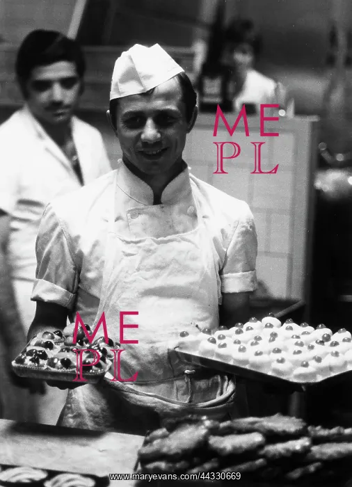 : Italy. A baker shown with some dishes of different pastries inside a bakery : Italy. A baker shown with some dishes of different pastries inside a bakery