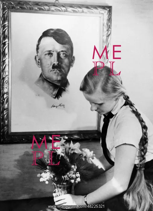 : BDM girl. A BDM girl puts flowers under a portrait of Adolf Hitler : BDM girl. A BDM girl puts flowers under a portrait of Adolf Hitler