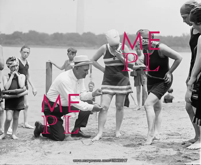 : A beach official checks the amount of thigh ? : A beach official checks the amount of thigh ?