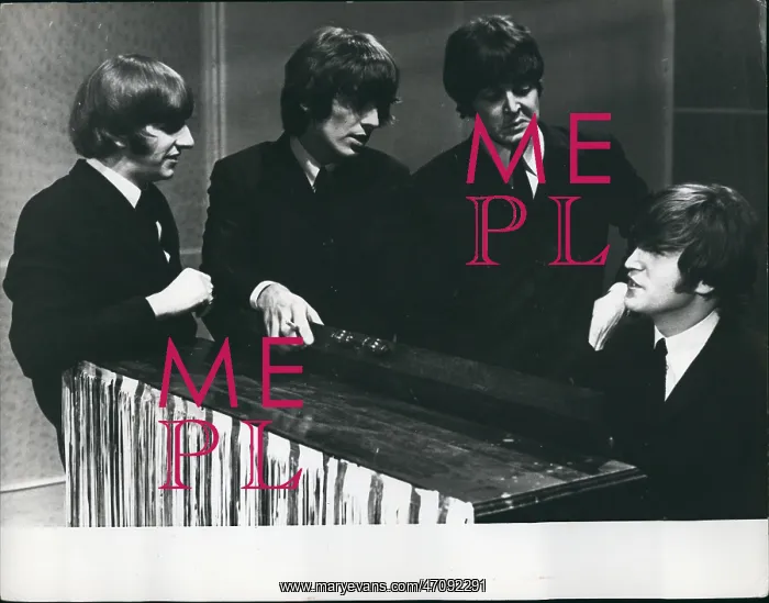 : The Beatles pop group, gathered round a piano : The Beatles pop group, gathered round a piano