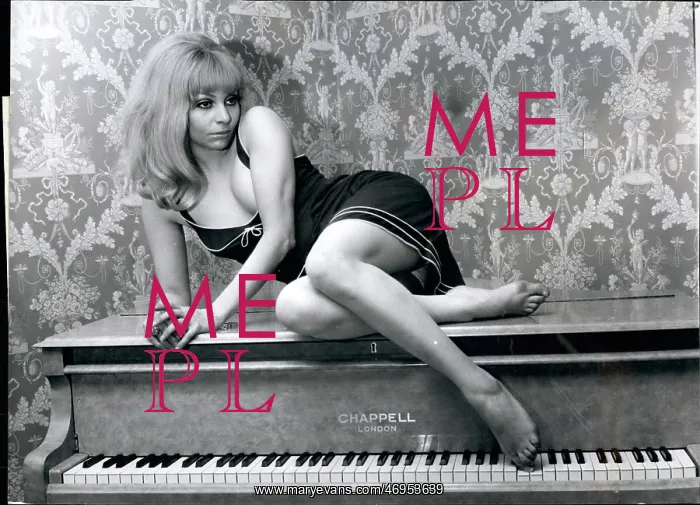 : Bernice Swanson posing on a piano : Bernice Swanson posing on a piano