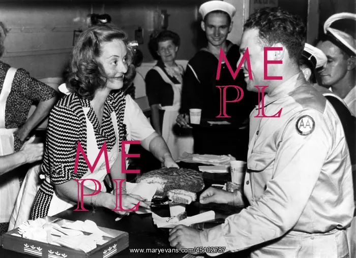  : Bette Davis serving cake to US servicemen at the