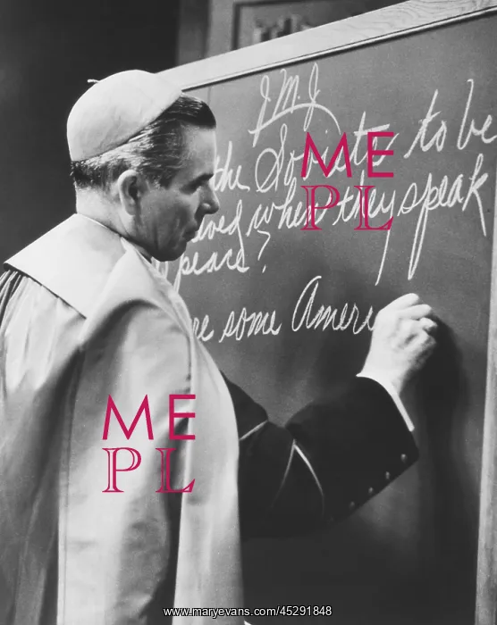 : Bishop Fulton Sheen writing on blackboard during : Bishop Fulton Sheen writing on blackboard during