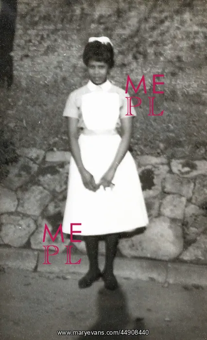 : Black nurse standing by a wall in the grounds of Woman's Hos : Black nurse standing by a wall in the grounds of Woman's Hos