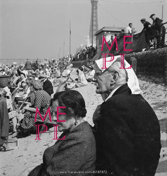 : Blackpool. Holiday makers on an crowded beach with an elderly couple in the foreground : Blackpool. Holiday makers on an crowded beach with an elderly couple in the foreground