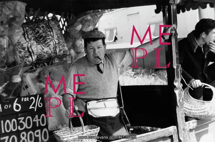 : Bored looking fairground stall attendant : Bored looking fairground stall attendant