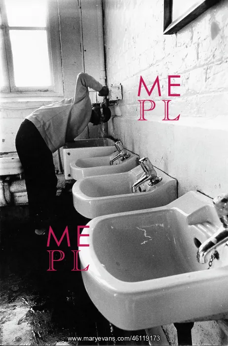 : Boy drinking from a tap in the school toilets : Boy drinking from a tap in the school toilets