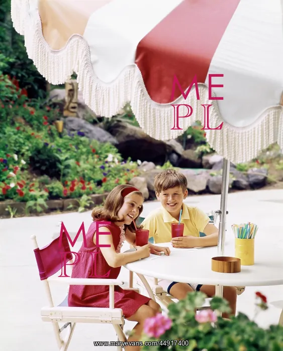 : Boy and Girl with Cool Drinks at Table with Large Umbre : Boy and Girl with Cool Drinks at Table with Large Umbre