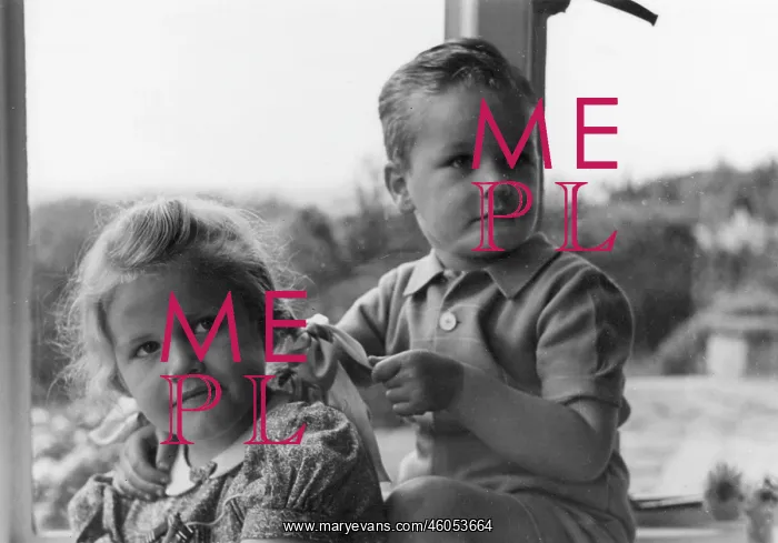 : Boy and girl sitting in a window : Boy and girl sitting in a window