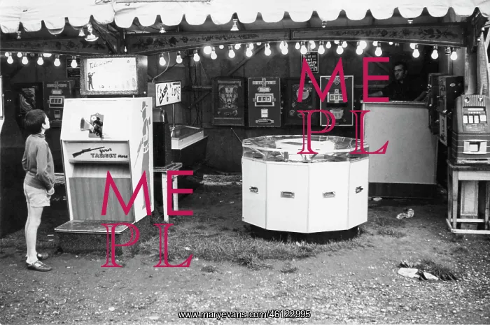 : Boy looking at shooting game in fairground arcade : Boy looking at shooting game in fairground arcade