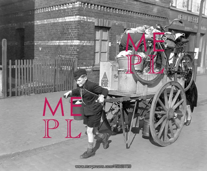 : A boy pulls, as his mother pushes, a cart loaded : A boy pulls, as his mother pushes, a cart loaded