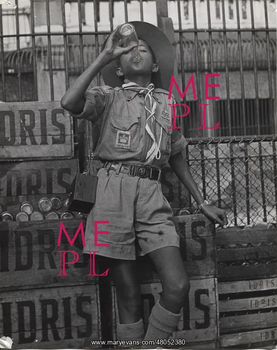 : Boy scout drinking from a bottle of Idris, Mauritius : Boy scout drinking from a bottle of Idris, Mauritius