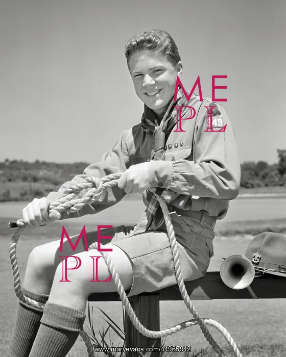 : Boy Scout Tying Knots in Rope Smiling Looking : Boy Scout Tying Knots in Rope Smiling Looking