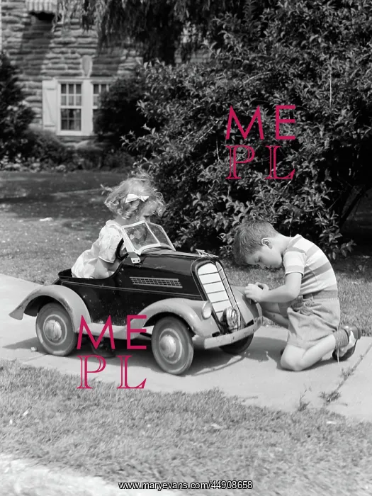 : Boy on sidewalk fixing headlight of toy car driven : Boy on sidewalk fixing headlight of toy car driven