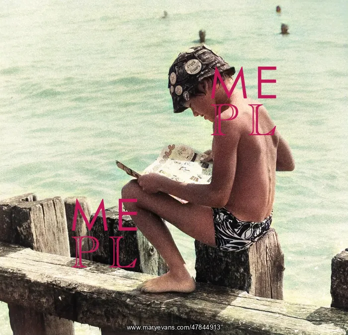 : Boy sitting on breakwater reading a comic : Boy sitting on breakwater reading a comic
