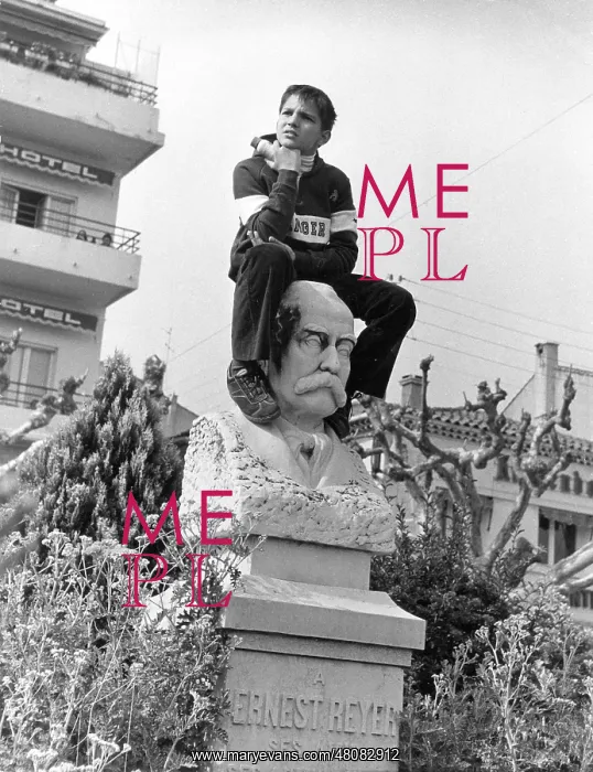 : Boy sitting on portrait bust, Le Lavandou, South of France : Boy sitting on portrait bust, Le Lavandou, South of France