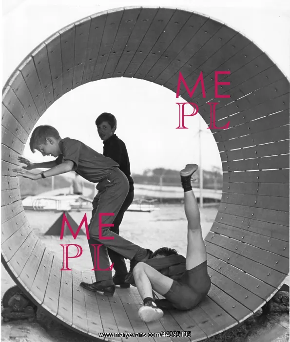 : Three boys playing inside a large barrel : Three boys playing inside a large barrel