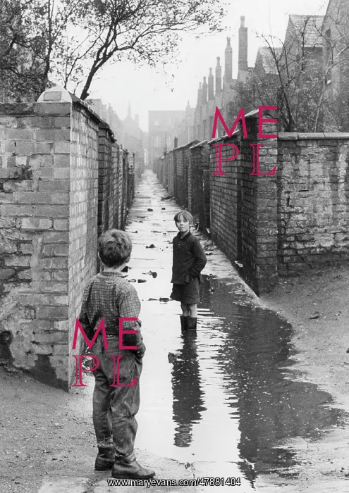 : Two boys playing in a large puddle - Manchester, 1966 : Two boys playing in a large puddle - Manchester, 1966