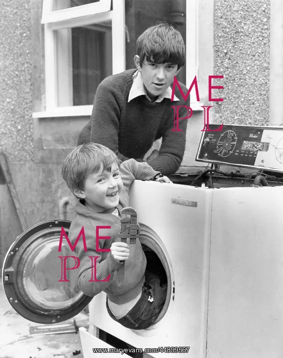 : Two boys playing in old washing machine : Two boys playing in old washing machine