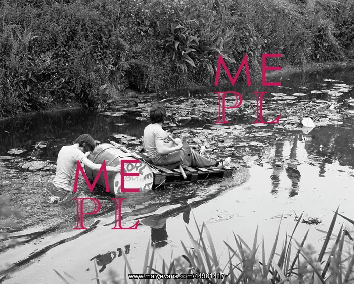 : Two boys with a raft make their way along a river : Two boys with a raft make their way along a river