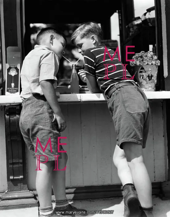 : Boys sharing a soda with two straws leaning on : Boys sharing a soda with two straws leaning on
