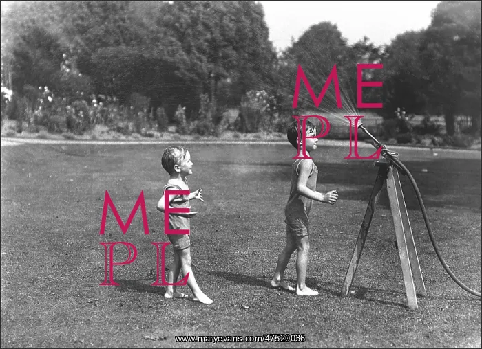 : Two boys with a water hose in a Devon garden : Two boys with a water hose in a Devon garden